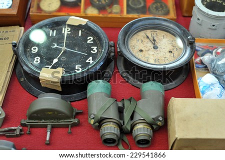 MILAN, ITALY - NOV 1: Old clocks and binoculars, Exhibitor sitting in his stand at Militalia, exhibition dedicated to militaria collectors and military associations on November 1, 2014 in Milan.