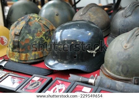 MILAN, ITALY - NOV 1: Helmets and miscellaneous items, Exhibitor sitting in his stand at Militalia, exhibition dedicated to militaria collectors and military associations on November 1, 2014 in Milan.