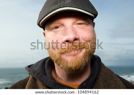 Handsome Irish Man with a red beard wearing a duckbill cap