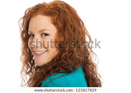 A pretty woman with red hair looking back over her shoulder.