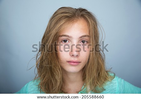 A pretty young teenaged girl with a serious expression