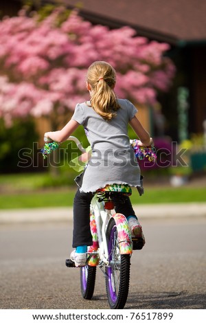 young girl riding a bike outside