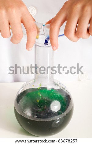 Yellow and Blue make green liquid in a beaker during a science experiment.