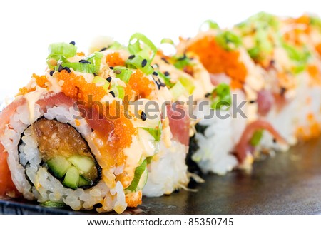 A colorful spicy Ahi tuna roll with raw seafood, fish eggs, avocado, rice and more.  Delicious Asian cuisine.
