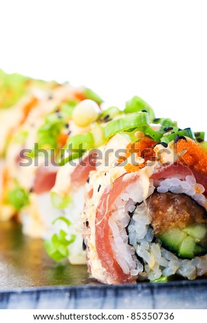 A colorful spicy Ahi tuna roll with raw seafood, fish eggs, avocado, rice and more.  Delicious Asian cuisine.