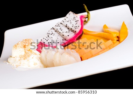 An exotic, tropical fruit plate with fresh dragon fruit, lychee, cantaloupe, and mango.