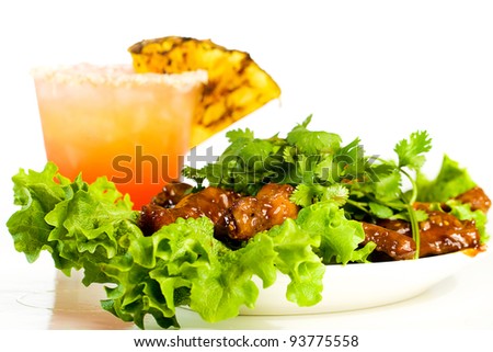 A tropical, fruity drink with a plate of barbecue buffalo chicken wings.