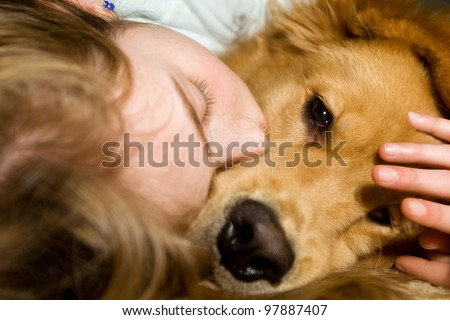 A young girl sound asleep and snuggled up with her Golden Retriever dog.