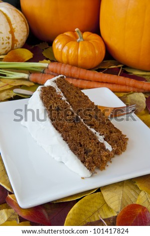 Piece of carrot cake with carrots and pumpkins