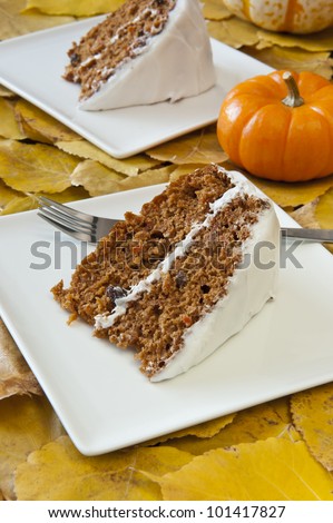 Two slices of carrot cake with colorful fall leaves