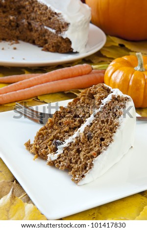 Slice of carrot cake with carrots and pumpkins