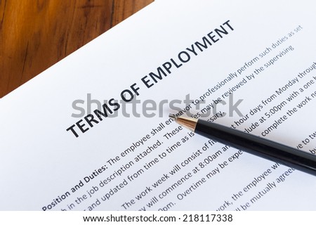Contract outlining the terms of employment with a pen