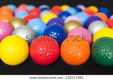 Assortment of colorful mini golf balls on black