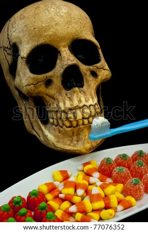 Halloween skull with a toothbrush and a plate of candy
