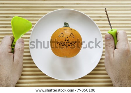 Hands with carving tools are ready to carve the pumpkin