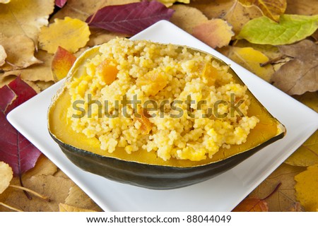Acorn squash stuffed with couscous and apricots with colorful fall leaves