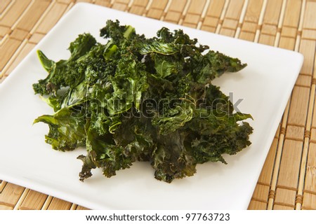 Nutritious snack of roasted kale chips on a white plate