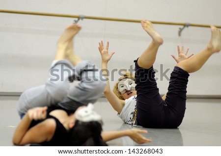 BARCELONA - MAR 3: Two actresses lying on the ground with masks play Commedia dell\'arte on March 3, 2011 in Barcelona, Spain. Is a form of theater characterized by masked types which began in Italy.
