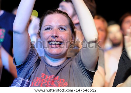 BENICASIM, SPAIN - JULY 18: A woman from the audience watches a concert at FIB (Festival Internacional de Benicassim) 2013 Festival on July 18, 2013 in Benicasim, Spain.