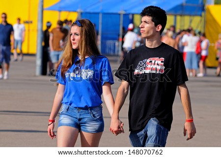 BENICASIM, SPAIN - JULY 19: A young couple, both with an Arctic Monkeys band shirt, at FIB (Festival Internacional de Benicassim) 2013 Festival on July 19, 2013 in Benicasim, Spain.