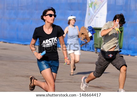 BENICASIM, SPAIN - JULY 19: A girl with an Arctic Monkeys band shirt, runs to catch the first row at FIB (Festival Internacional de Benicassim) 2013 Festival on July 19, 2013 in Benicasim, Spain.