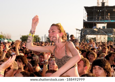 BENICASIM, SPAIN - JULY 19: Young woman dances above the crowd in a concert at FIB (Festival Internacional de Benicassim) 2013 Festival on July 19, 2013 in Benicasim, Spain.