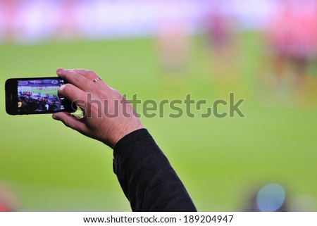 BARCELONA - APR 21: A supporter of F.C. Barcelona football team, recording a goal with his mobile phone camera at the Camp Nou Stadium on April 21, 2014 in Barcelona, Spain.