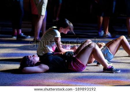 BENICASIM, SPAIN - JULY 19: Two women watch a concert sitted on the floor at FIB  Festival on July 19, 2013 in Benicasim, Spain.