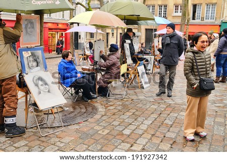 PARIS - MAR 1: Public painter with his paintings in Place du Tertre square in Paris' XVIIIe arrondissement (Montmartre) on March 1, 2014 in Paris, France. Montmartre was the mecca of modern art.