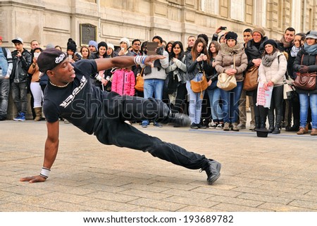 PARIS - MAR 1: People watch a homeless streetdancer doing breakdance and dance moves in the streets of Paris to earn some money on March 1, 2014 in Paris, France.