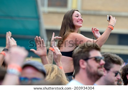 BARCELONA - JUN 13: A woman does a selfie from above the audience at Sonar Festival on June 13, 2014 in Barcelona, Spain.