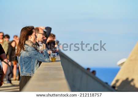 BARCELONA - MAY 30: Woman from the audience watches a concert a drinks a beer at Heineken Primavera Sound 2014 Festival (PS14) on May 30, 2014 in Barcelona, Spain.