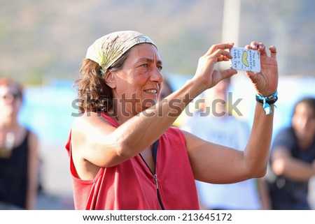 BENICASSIM, SPAIN - JULY 20: A woman from the crowd takes a picture with her smartphone camera at FIB Festival on July 20, 2014 in Benicassim, Spain.