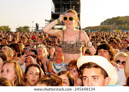 BENICASSIM, SPAIN - JULY 19: Young woman dances above the crowd in a concert at FIB (Festival Internacional de Benicassim) 2013 Festival on July 19, 2013 in Benicassim, Spain.