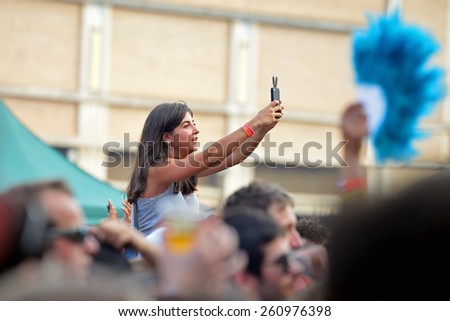 BARCELONA - JUN 12: A woman from the audience takes a selfie at Sonar Festival on June 12, 2014 in Barcelona, Spain.