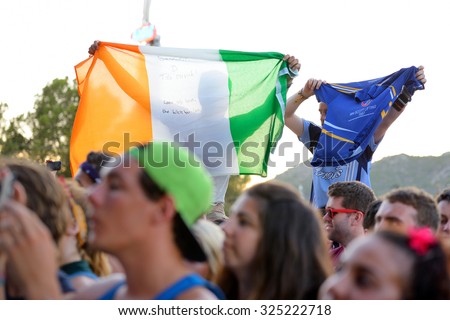 BENICASSIM, SPAIN - JULY 20: Young man from the crowd cheering, with an Irish flag, at FIB Festival on July 20, 2014 in Benicassim, Spain.