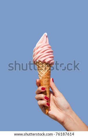 hand holding an ice cream cone of strawberry