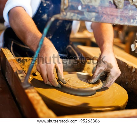 potter at work - potter\'s wheel, hands and a clay
