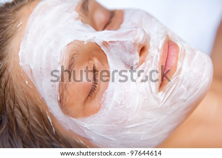 Young woman in the tropical spa making face mask