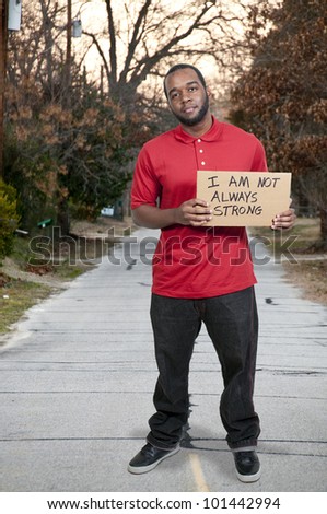Man holding up a sign that says I am not always strong