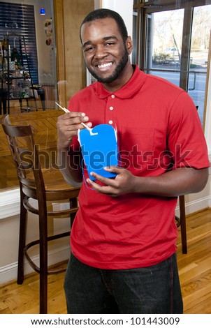 Black African American man eating Chinese or Japanese Asian food