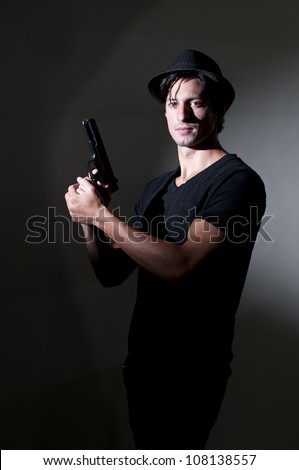 Handsome police private detective man on the job with a gun