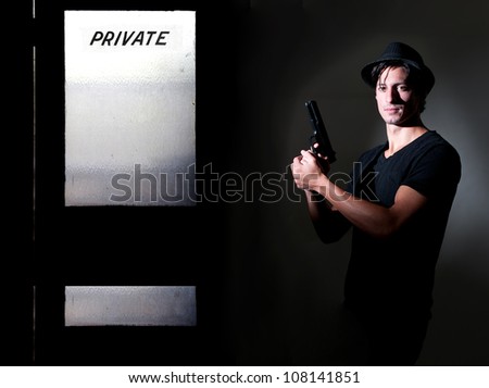 Handsome police private detective man on the job with a gun