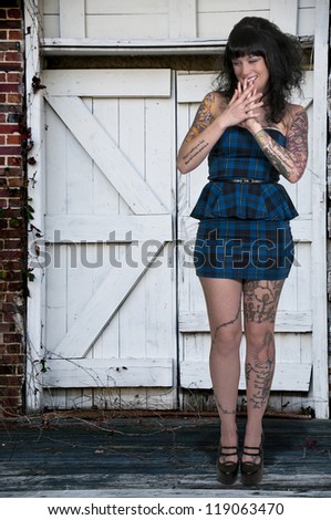 Beautiful tattooed young woman looking far away