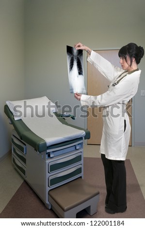 A beautiful female radiologist examining an x-ray
