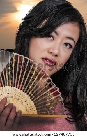 Beautiful Asian woman with an oriental fan