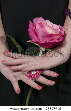 Beautiful woman holding a fresh cut rose
