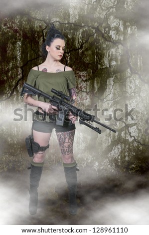 Beautiful young woman holding an automatic assault rifle
