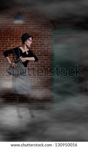 Beautiful scared woman pulling out a gun in a dark alley