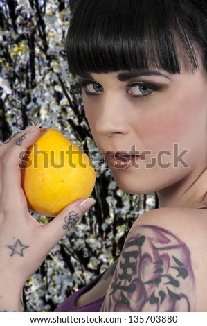Beautiful young woman holding a pear shes about to eat